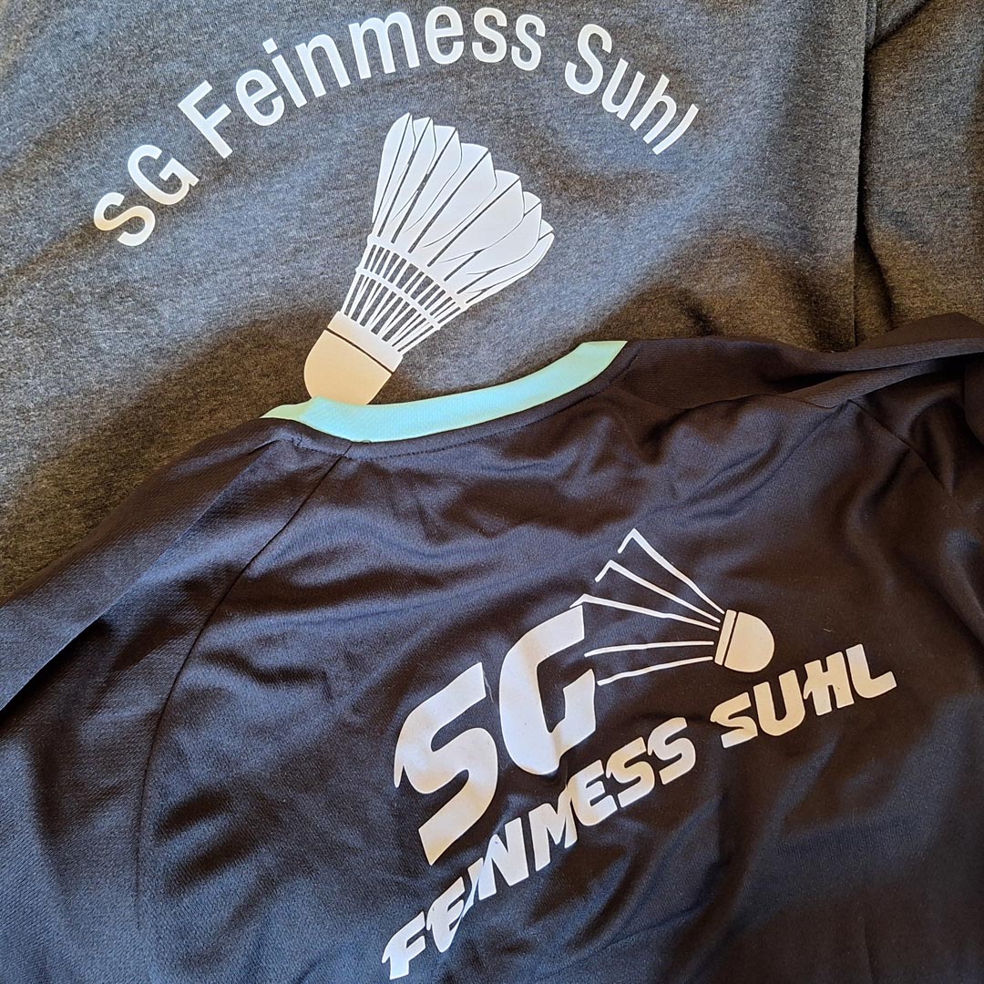 Hier ist ein Foto abgebildet, das einen Hoodie und ein Trikot der SG Feinmess Suhl zeigt.